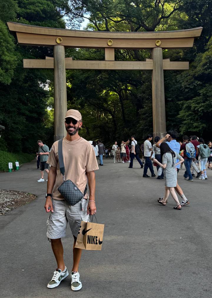 Des gens se rassemblent près d'un grand torii dans un cadre forestier.