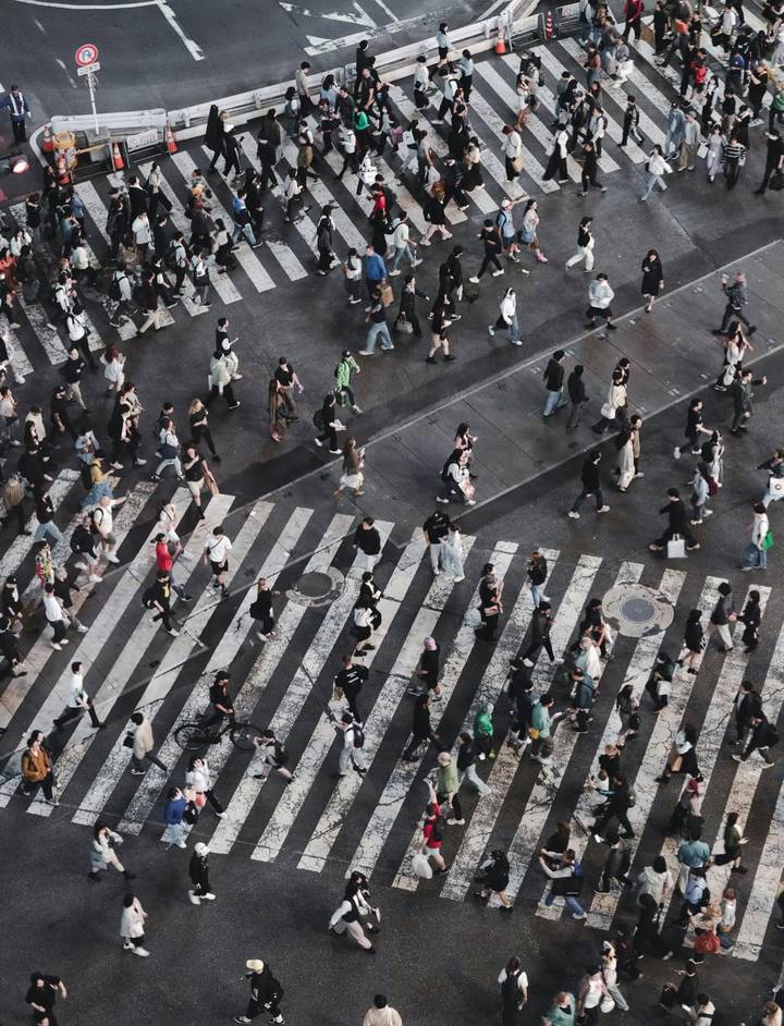 Des gens traversant une rue animée avec un passage piéton.