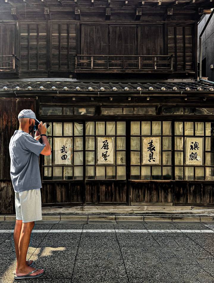 Personne photographiant une ancienne structure avec des fenêtres japonaises.