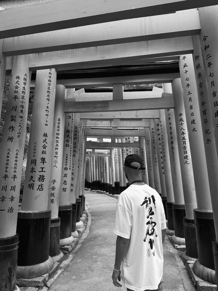 Une personne marchant à travers des torii dans un site de la période d'Edo.