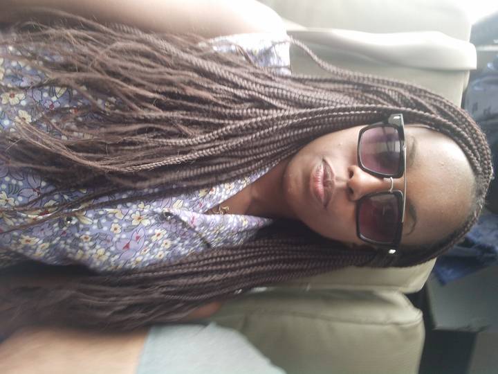 Gros plan d'une personne à l'intérieur avec des cheveux tressés.