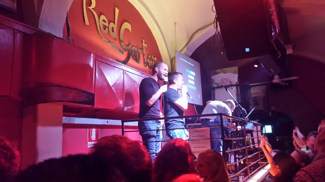 Two entertainers performing on stage in a lively venue.