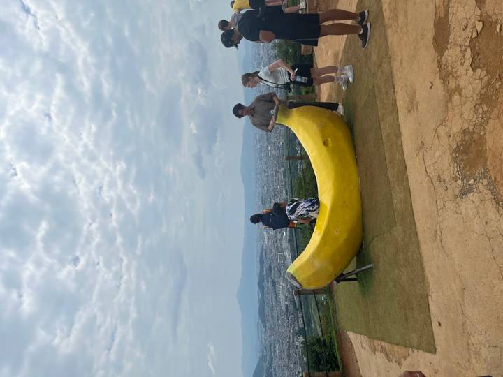 Des personnes posant avec une grande sculpture de banane à un point de vue.