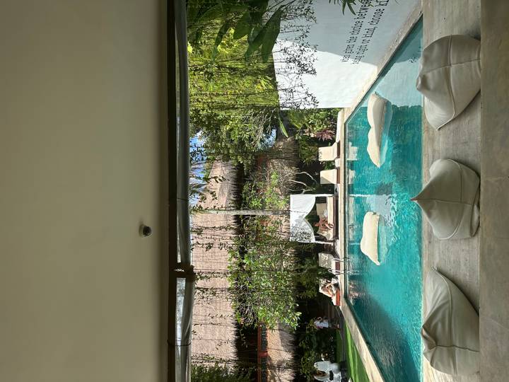 A serene pool area with people relaxing.