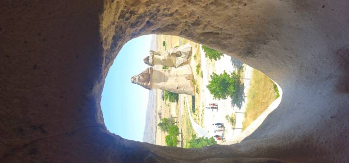 Vue de formations rocheuses uniques en Cappadoce à travers l'ouverture d'une grotte.