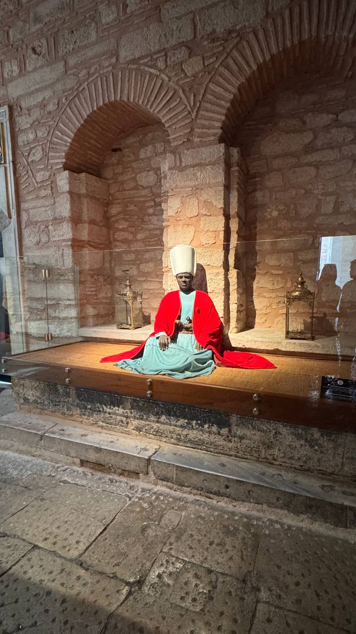 Statue d'une figure assise dans une vitrine.