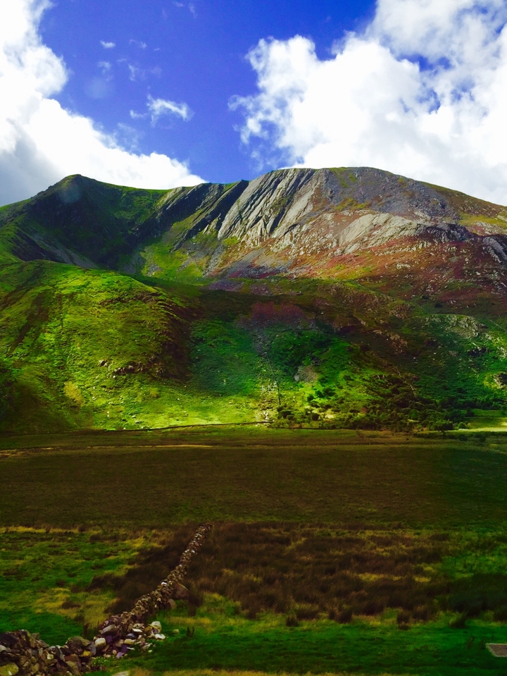 Vue panoramique de collines verdoyantes par une journée ensoleillée.