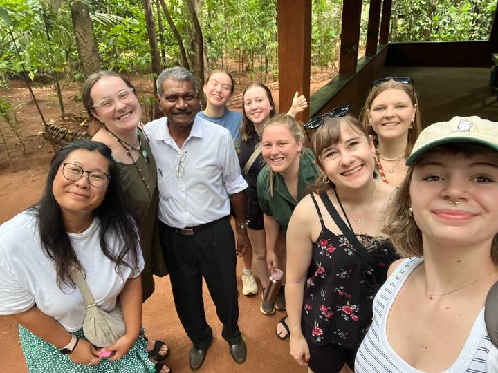 Un groupe de personnes avec un guide local debout dans un cadre naturel.