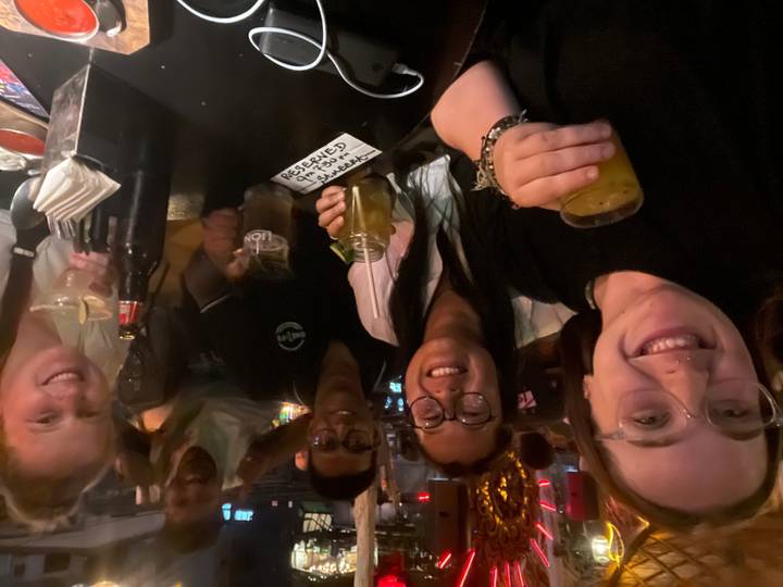 Un groupe dans un restaurant faiblement éclairé levant leurs verres.