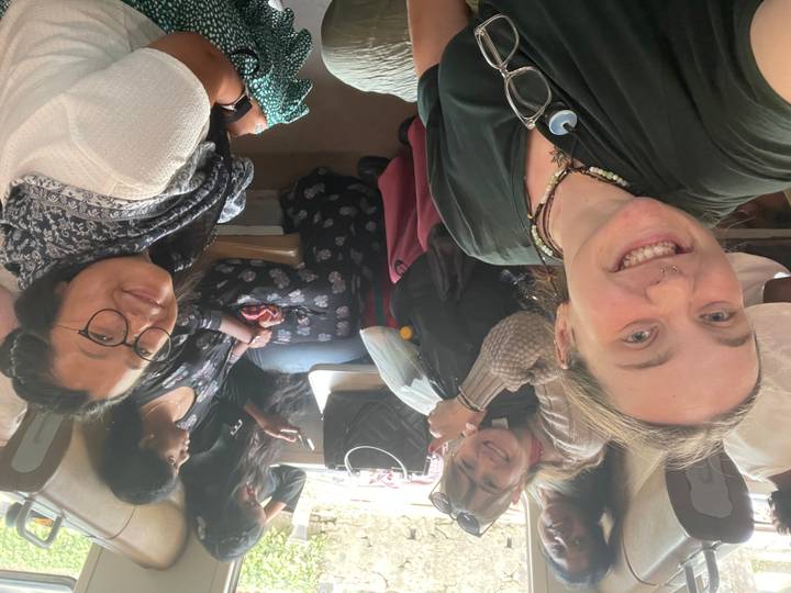 Groupe de personnes assises dans un bus bondé, souriantes.