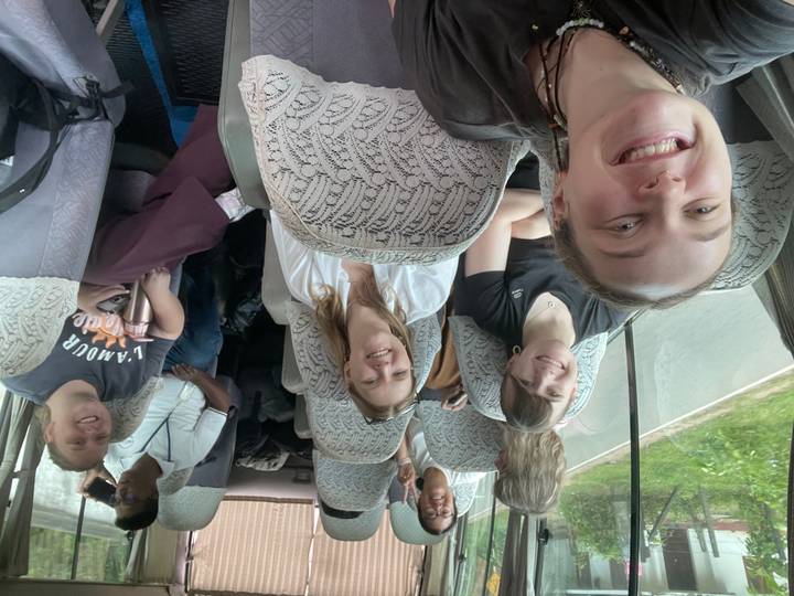 Un groupe de personnes souriantes assises dans une camionnette lors d'un voyage sur la route.