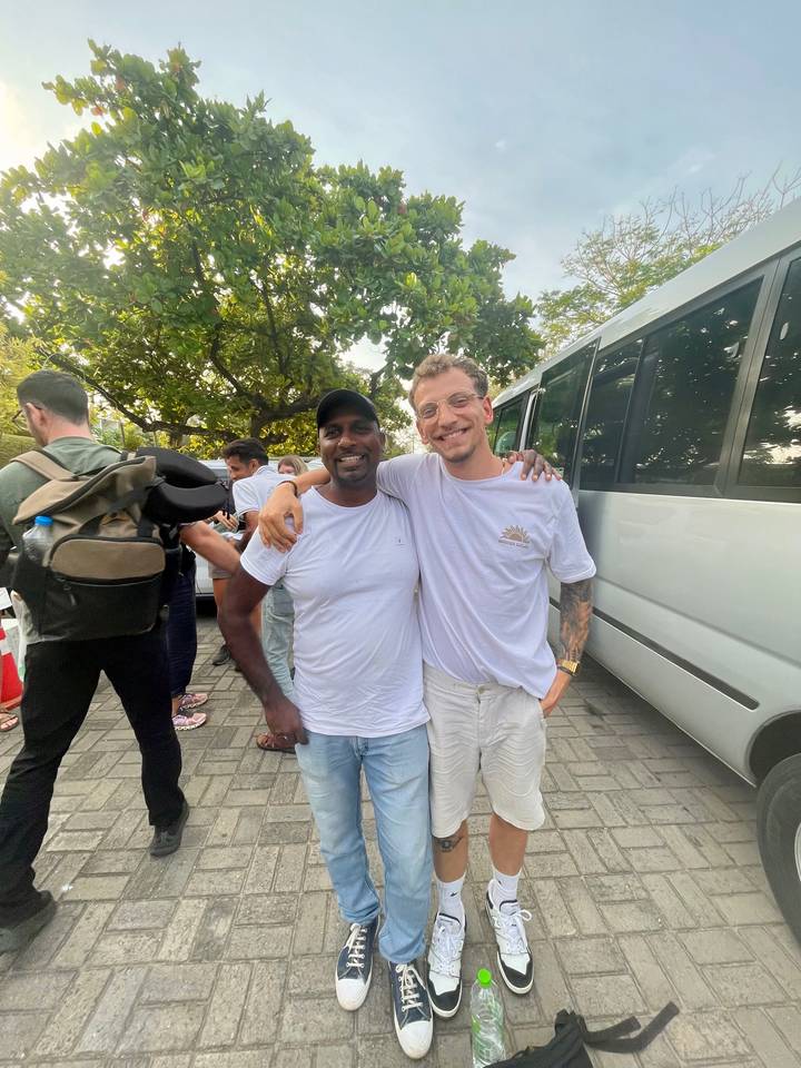 Deux personnes posant pour une photo avec une camionnette en arrière-plan.