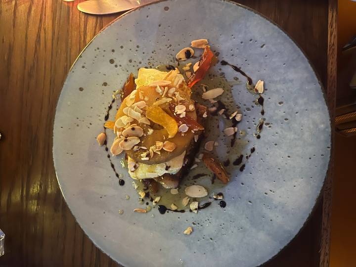 Dessertteller garniert mit Sauce und Nüssen.
