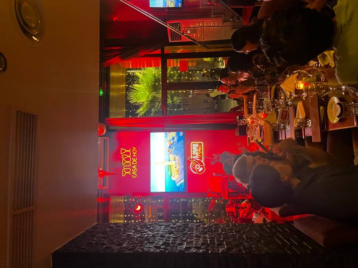 Innenrestaurant-Szene mit Neonlichtern und essenden Menschen.