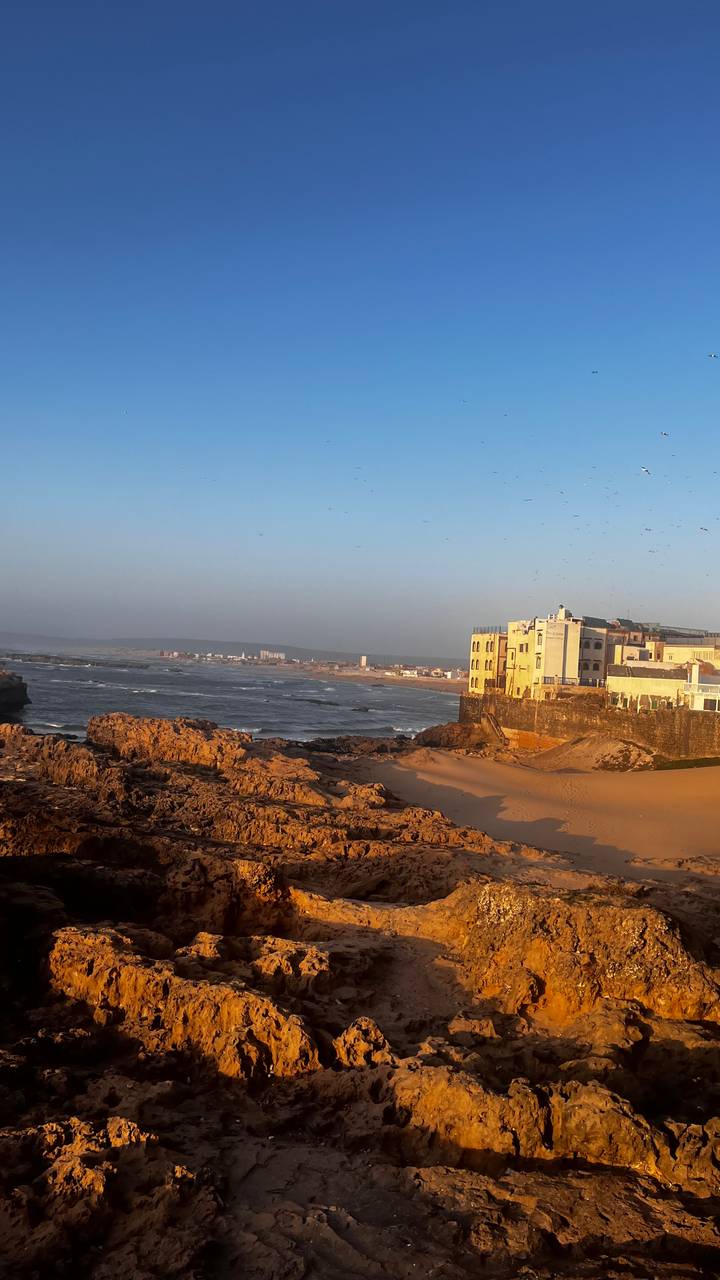 Küstenblick auf Gebäude am Meer mit malerischer Landschaft.