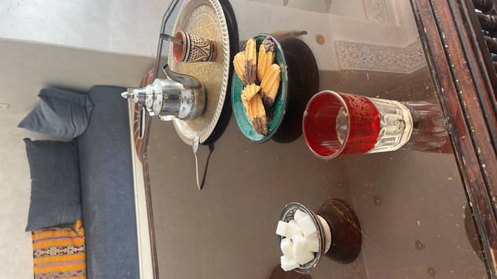 Traditionelles marokkanisches Tee-Set mit Snacks auf einem Tisch.
