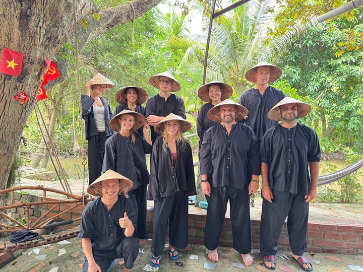 Groupe portant des chapeaux traditionnels et des vêtements posant pour une photo.