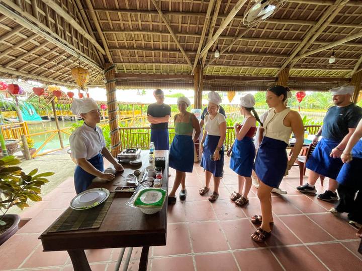 Groupe participant à un cours de cuisine dans une cuisine en plein air.