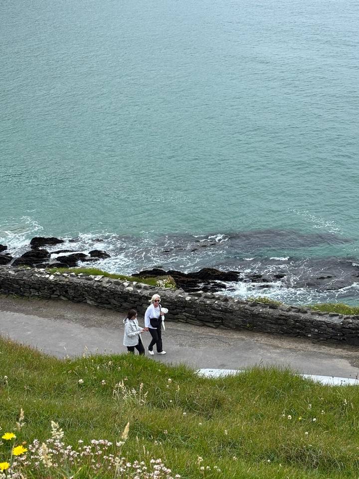 People walking on a path by the sea.