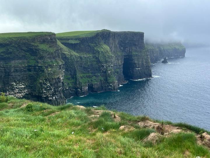 Cliffs of Moher with mist and dramatic views of the sea.