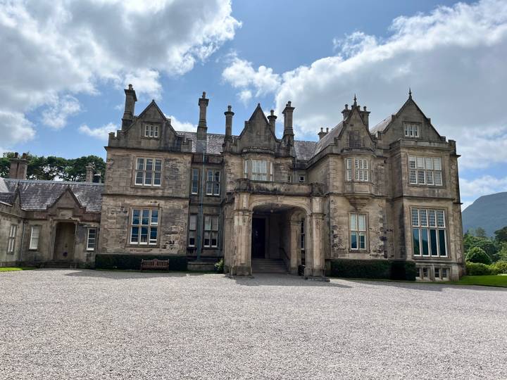 Historic stone mansion with green shutters.