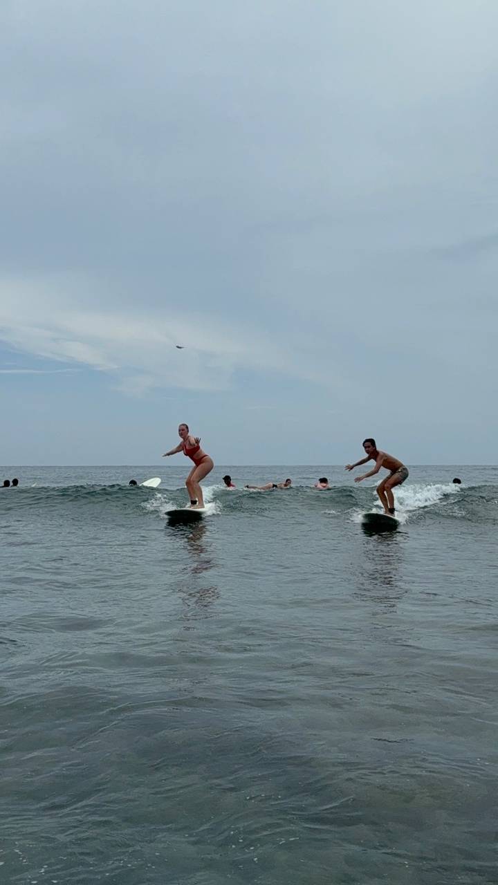 Des gens qui font du surf sur les vagues à la plage.