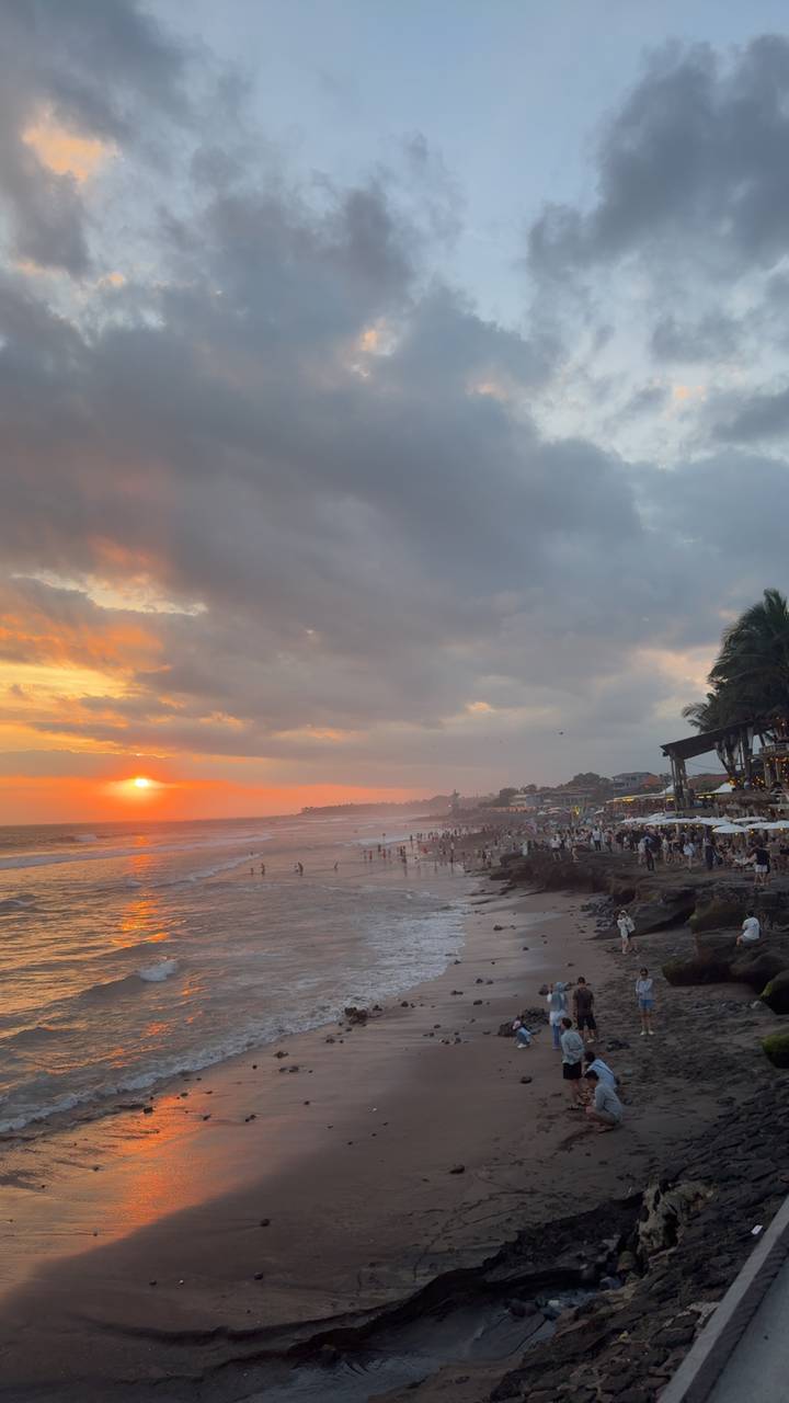 Vue du coucher de soleil sur une plage bondée