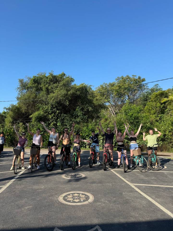 Groupe de cyclistes posant avec les mains levées par une journée ensoleillée