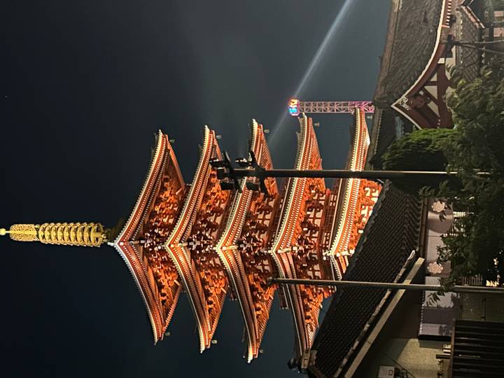 Pagode illuminée la nuit avec un ciel dégagé.