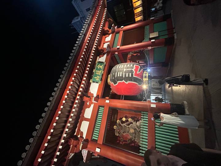Porte d'entrée célèbre avec lanterne géante illuminée la nuit.