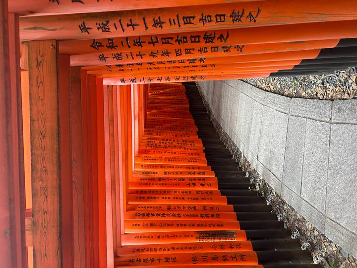 Vue à l'intérieur du tunnel de torii rouges avec inscriptions.
