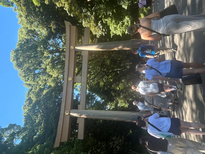 Groupe de touristes marchant à travers un grand torii historique.