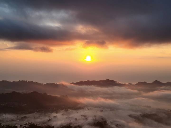Vue du lever de soleil sur des montagnes brumeuses.