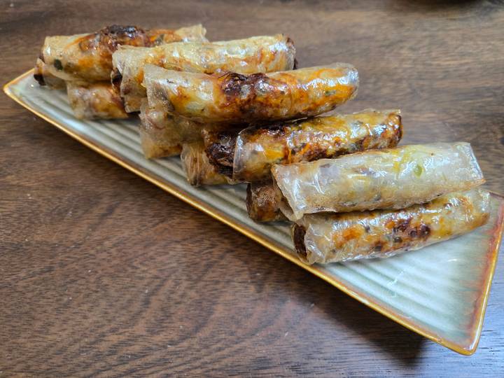 Un gros plan de rouleaux de printemps vietnamiens croustillants dans une assiette.