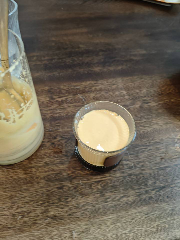 Un verre à moitié rempli d'une boisson brun clair.