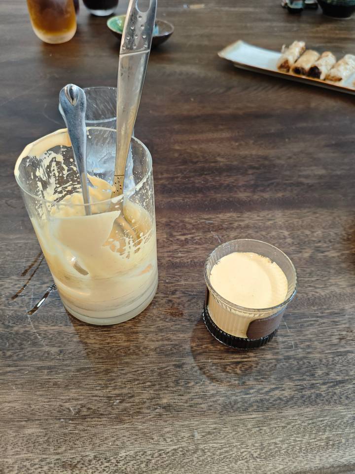Verre avec substance crémeuse à côté d'un autre verre.