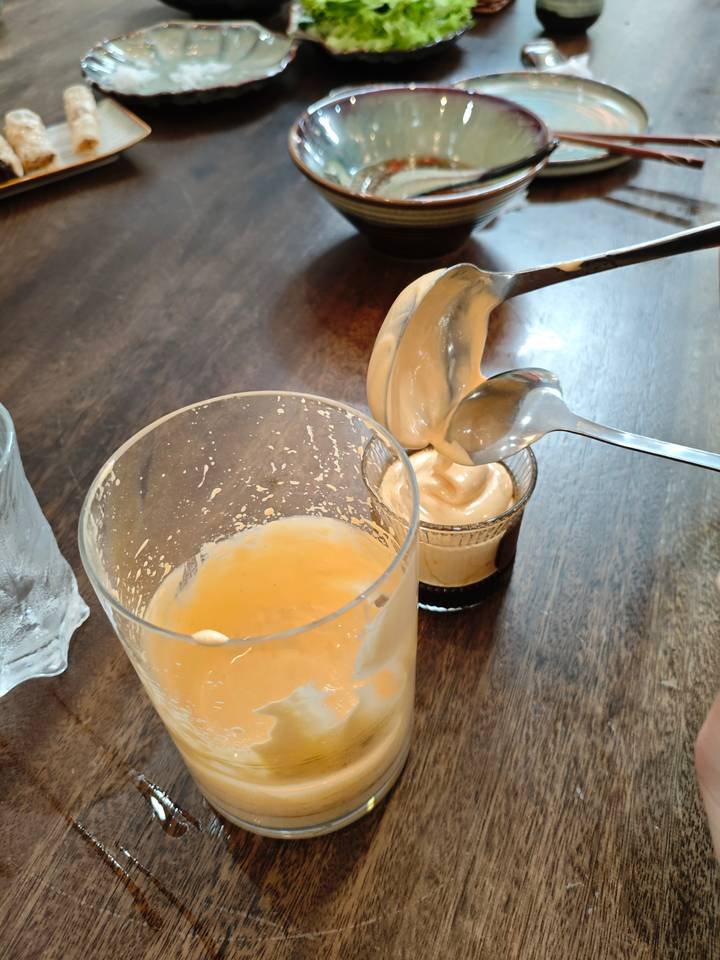 Cuillère transférant une substance crémeuse dans un verre.