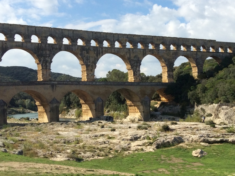 Pont du Gard, ancient Roman aqueduct bridge in lush landscape.