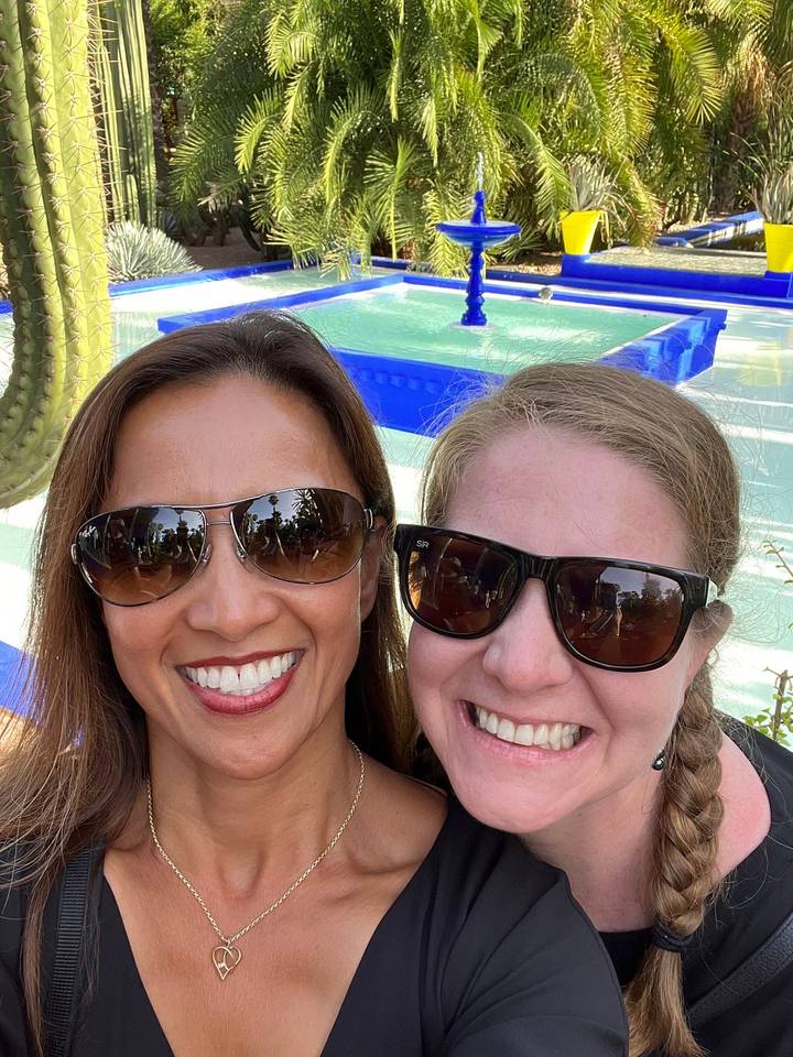 Deux femmes prenant un selfie avec une fontaine.