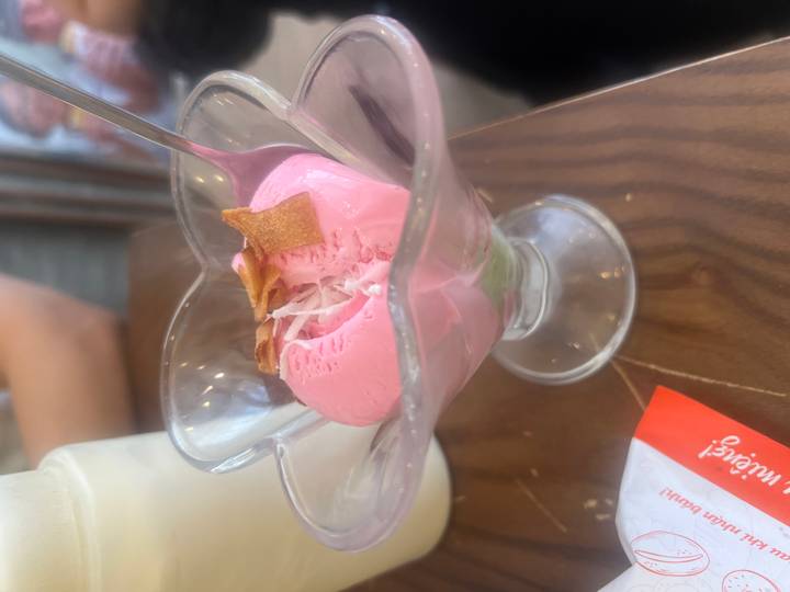 Glace rose dans un plat en verre sur une table.