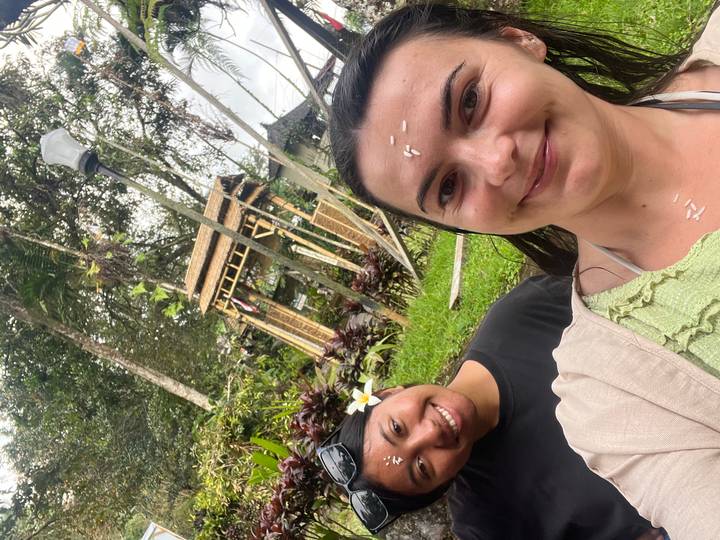 Deux femmes souriantes avec un arrière-plan traditionnel.