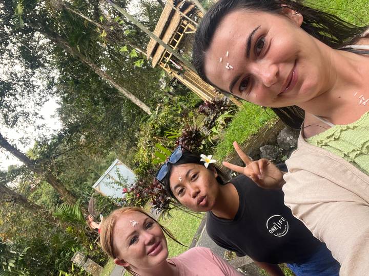 Trois femmes faisant des gestes enjoués dans un jardin.