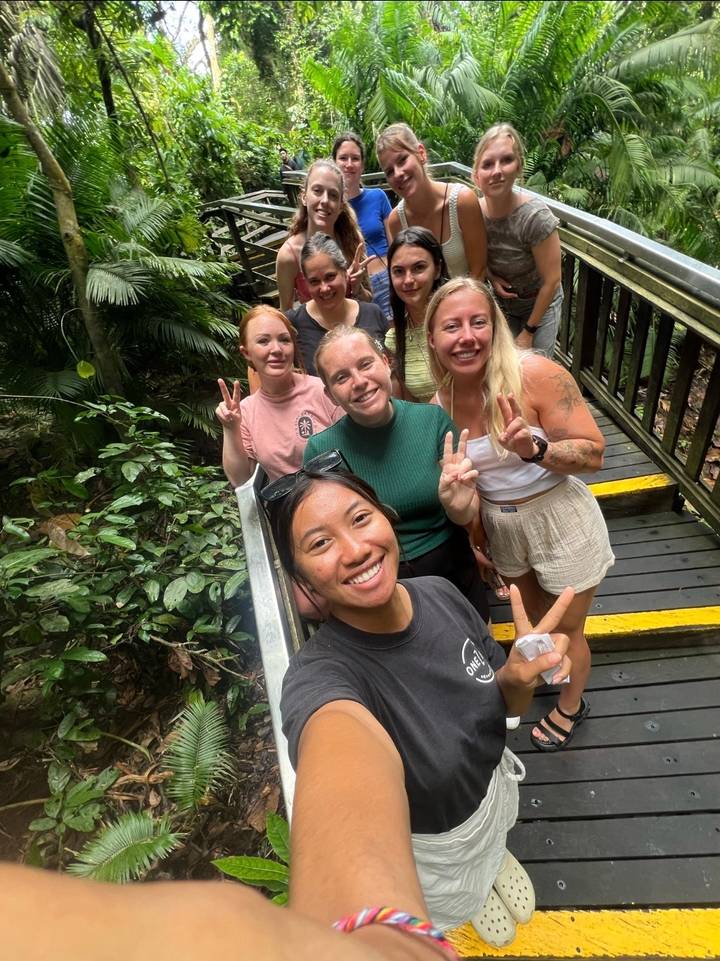 Groupe d'amis prenant un selfie dans un cadre de jungle luxuriante.