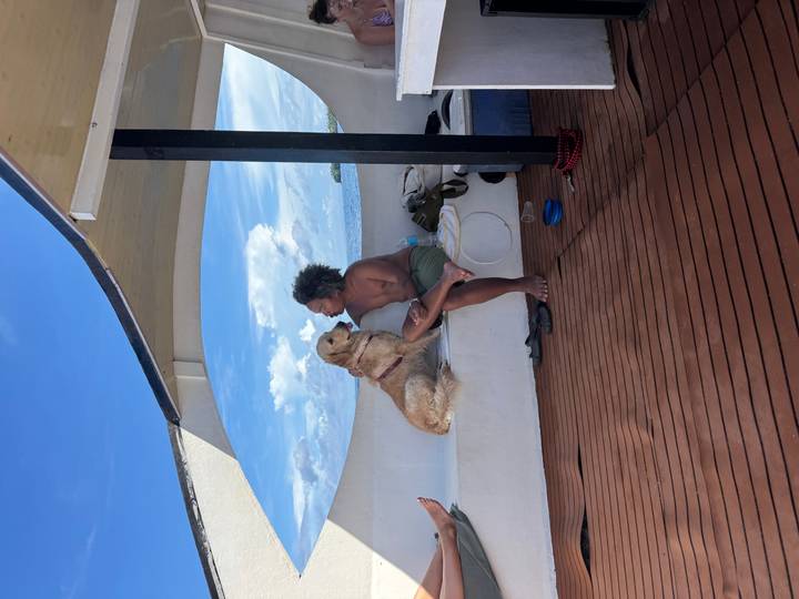 Person sitting with a dog on a boat.