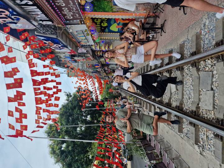 Touristes prenant la pose sur une voie ferrée avec des drapeaux festifs