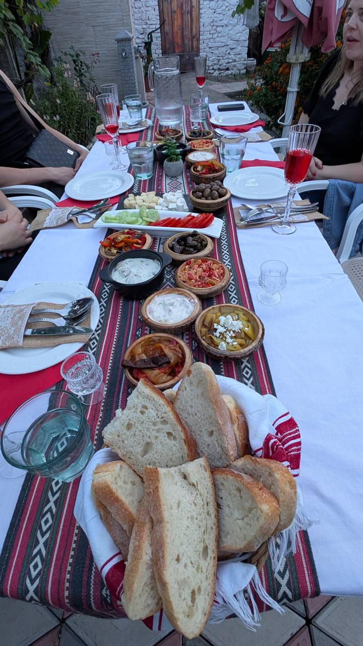 Plats albanais traditionnels servis sur une nappe à motifs.