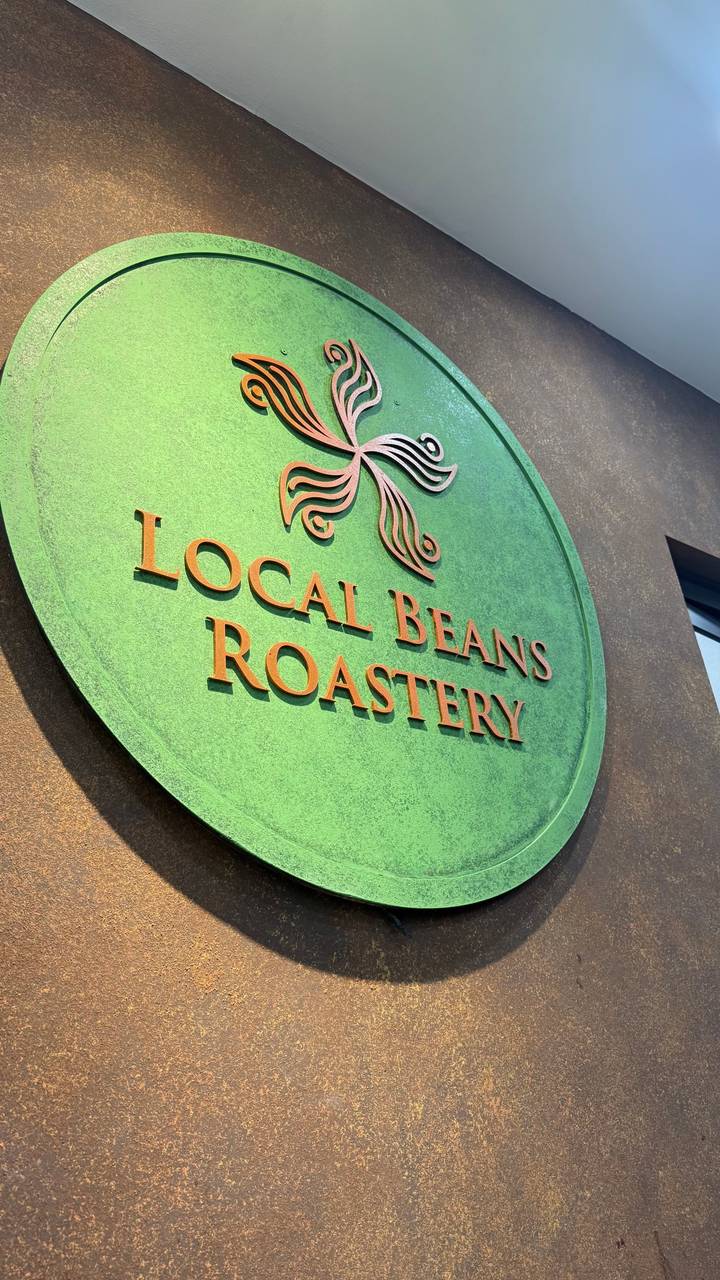 Sign for 'Local Beans Roastery' in green and orange shades.