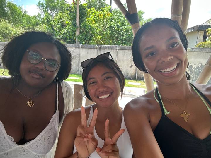 Trois femmes souriant pour un selfie en plein air.