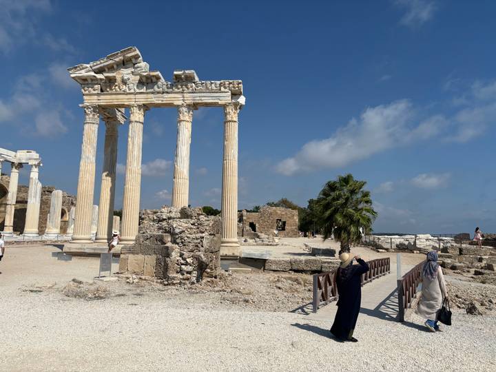 Ruines anciennes avec des gens qui prennent des photos.