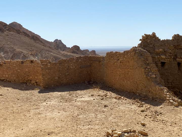 Paysage désertique avec des ruines rocheuses et des montagnes.